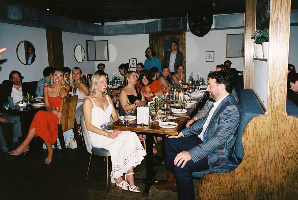 The couple surrounded by family and friends at their intimate rehearsal dinner at Intero Restaurant in Austin, TX, glowing on film
