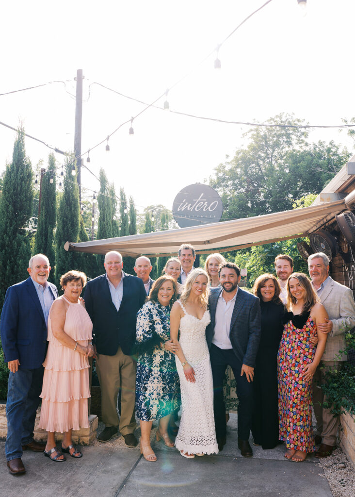 The couple surrounded by family and friends at their intimate rehearsal dinner at Intero Restaurant in Austin, TX, glowing in warm film tones.