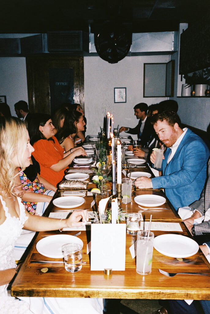 The couple surrounded by family and friends at their intimate rehearsal dinner at Intero Restaurant in Austin, TX, glowing on film