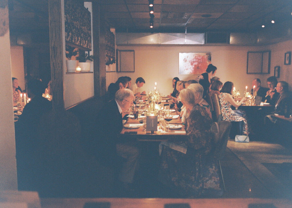 Film photograph of rehearsal dinner guests enjoying an intimate evening at Intero Restaurant.