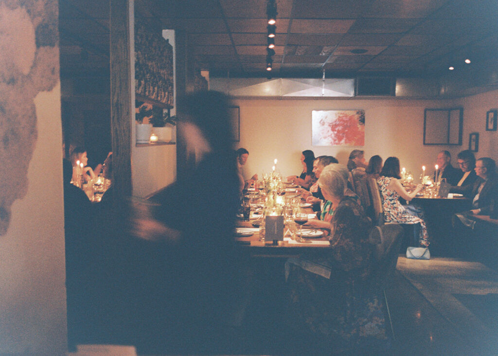 Film photograph of rehearsal dinner guests enjoying an intimate evening at Intero Restaurant.