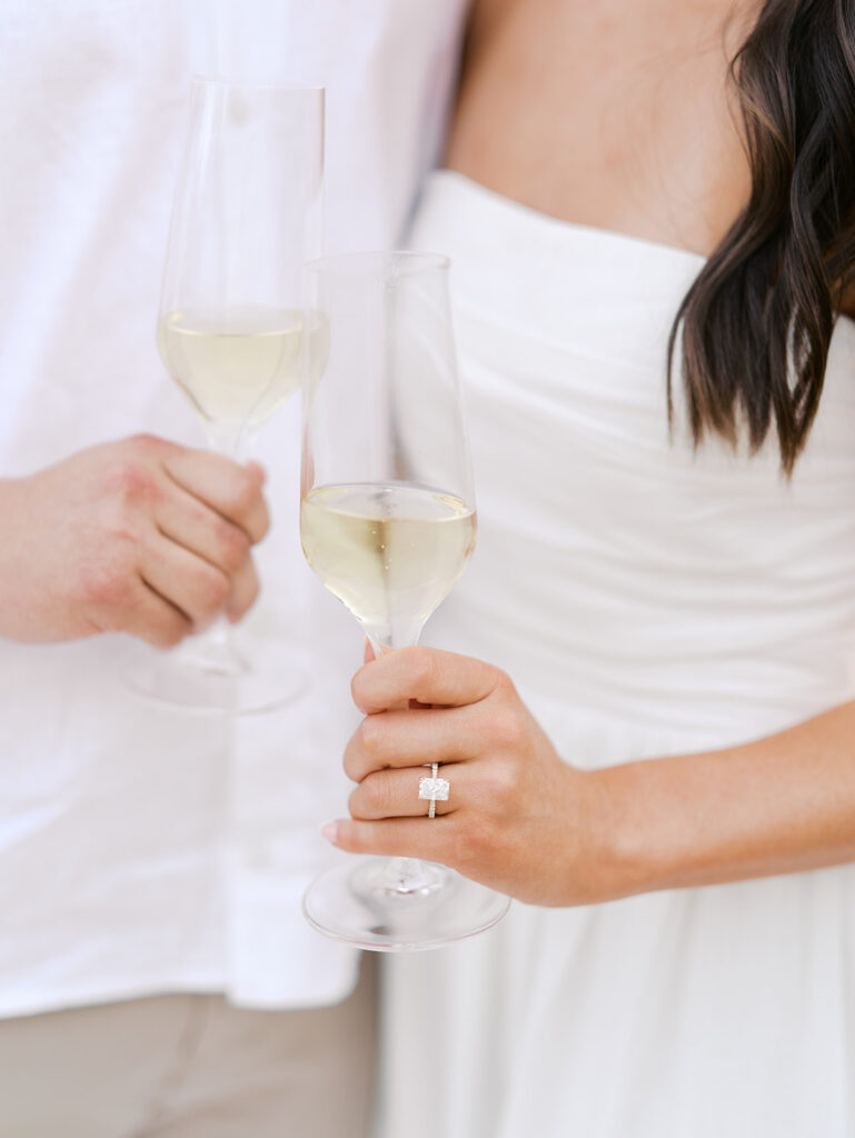 Lake Travis proposal photography featuring a couple popping champagne by the lakeside after saying yes.
