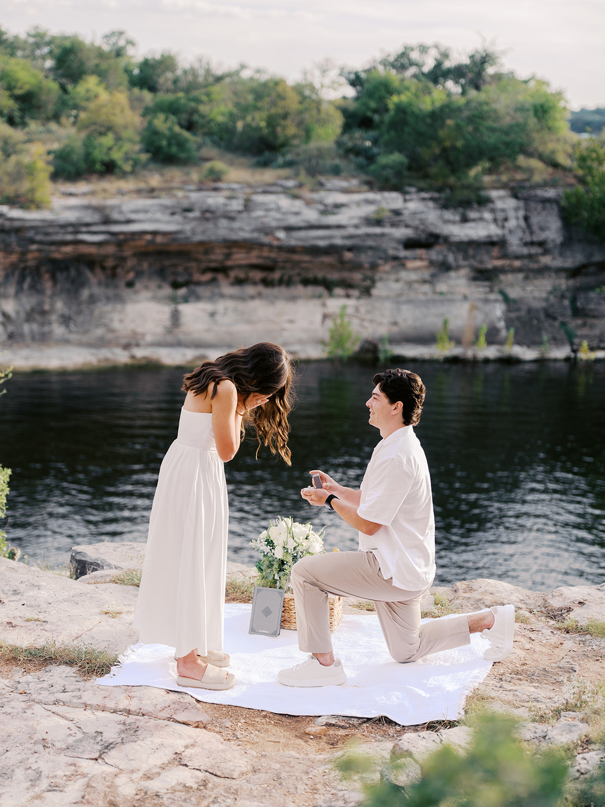 Surprise proposal on Lake Travis as he kneels with a ring, captured in dreamy, romantic photography.