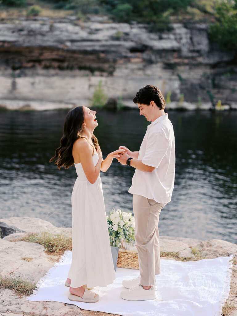 Surprise proposal on Lake Travis as he kneels with a ring, captured in dreamy, romantic photography.