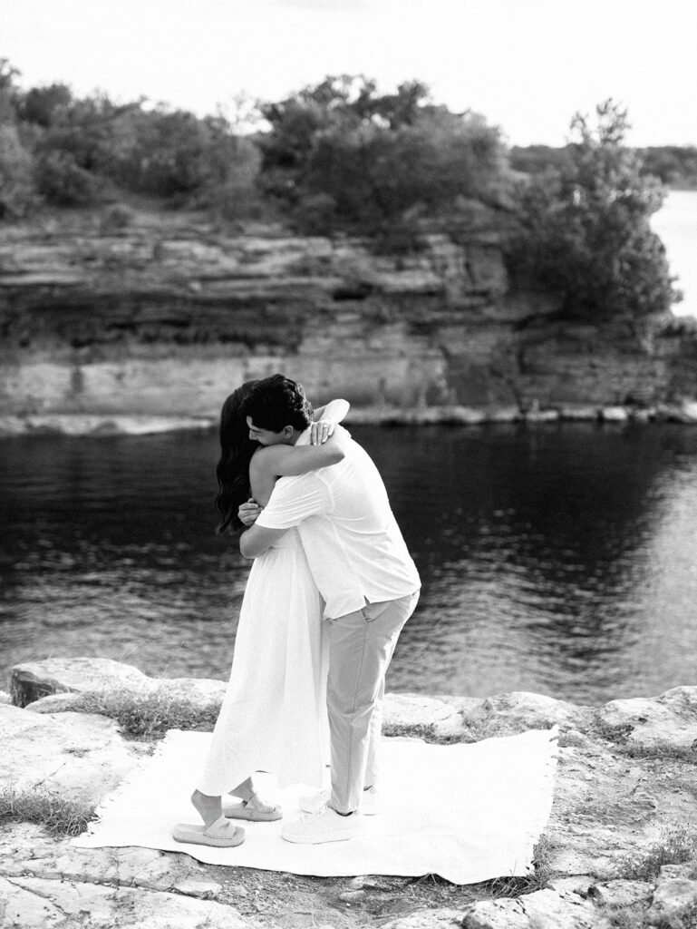 Surprise proposal on Lake Travis as he kneels with a ring, captured in dreamy, romantic photography.