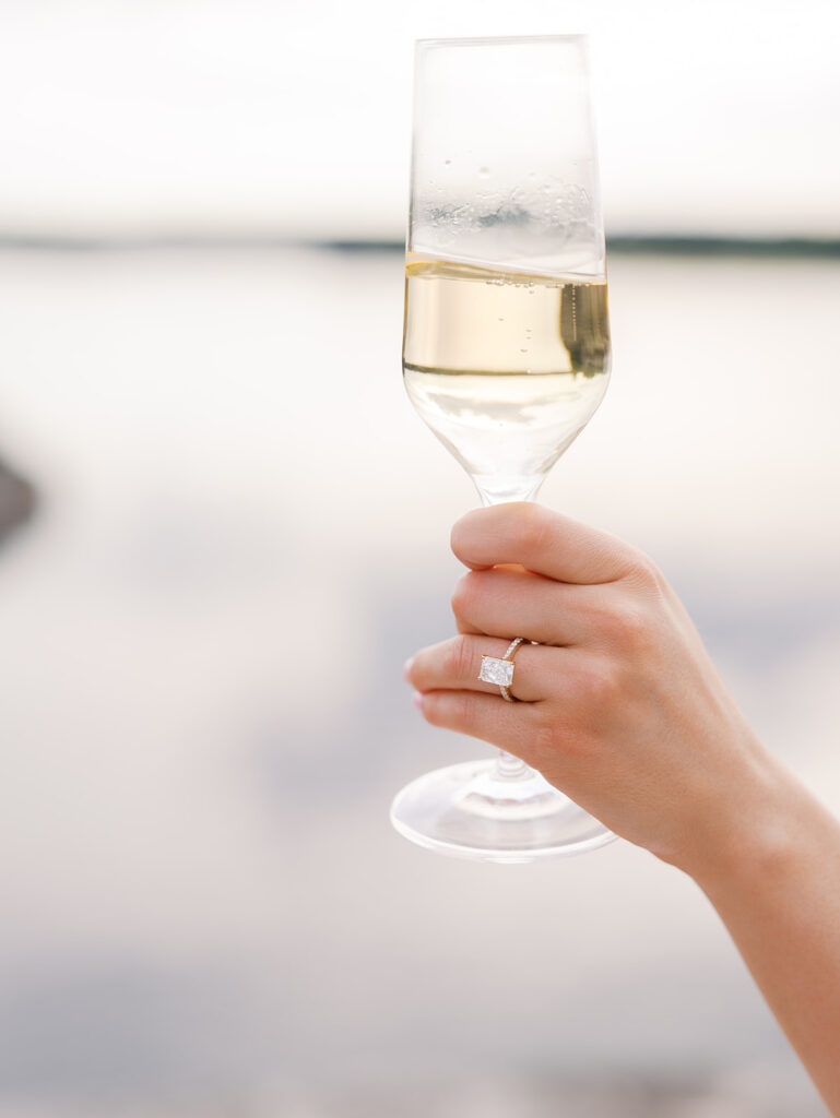 Lake Travis proposal photography featuring a couple popping champagne by the lakeside after saying yes.