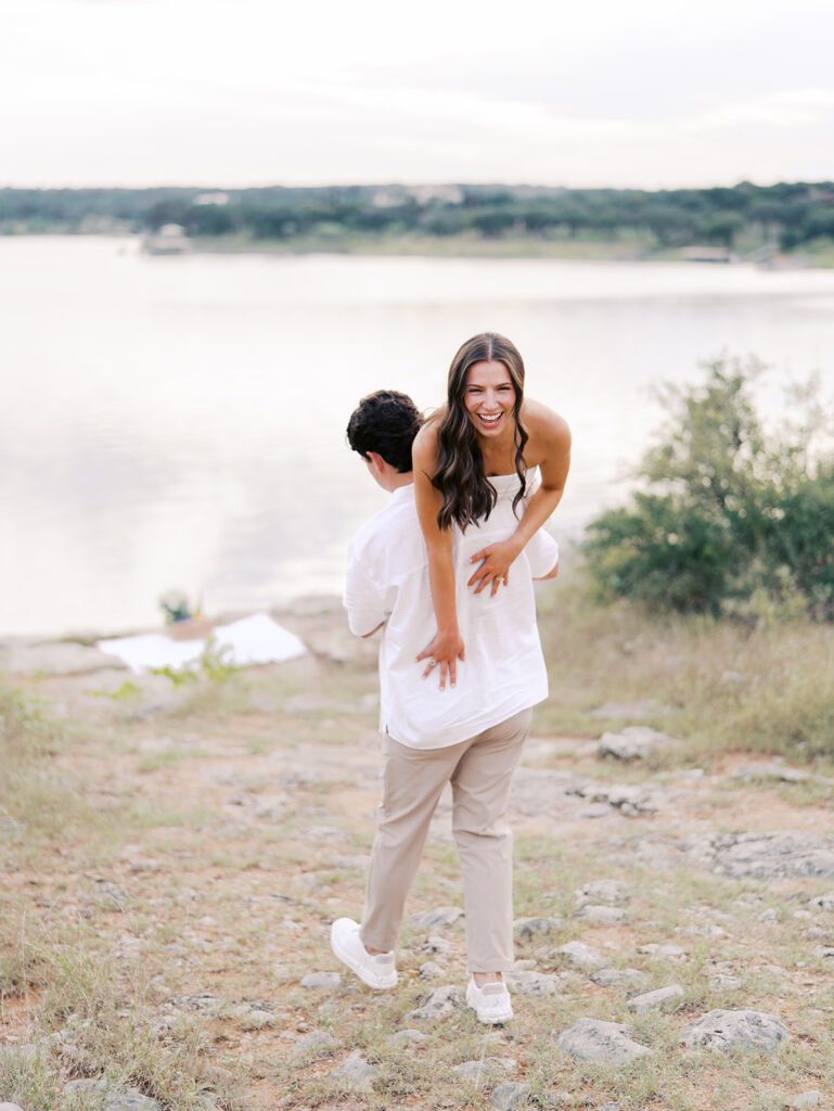 Playful and candid Lake Travis proposal photography of newly engaged couple enjoying the moment together.