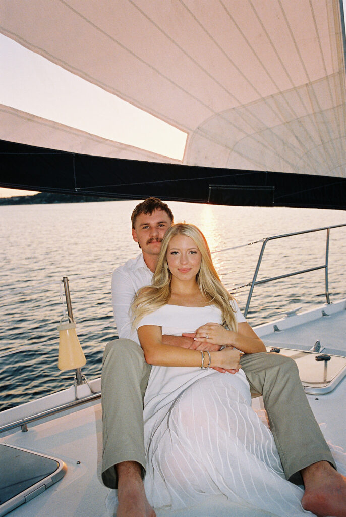 Romantic Lake Travis engagement photography with sailboat sunset views and playful, candid moments.