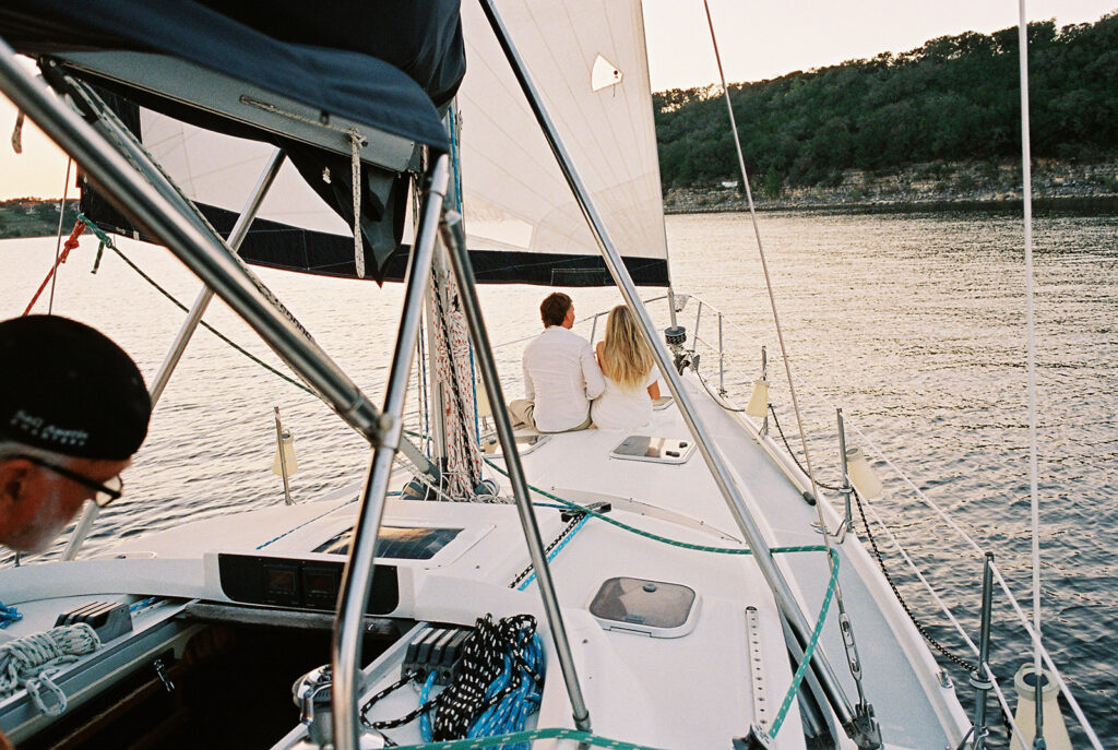 Romantic Lake Travis engagement photography with sailboat sunset views and playful, candid moments.