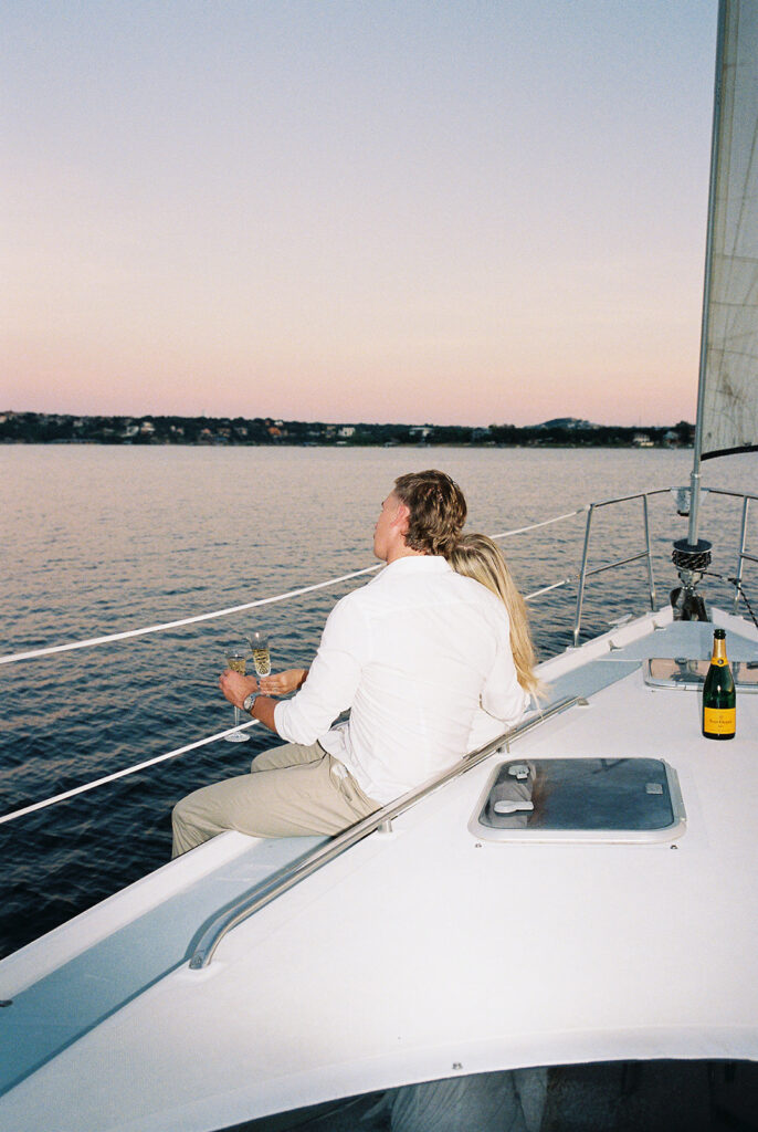 Romantic Lake Travis engagement photography with sailboat sunset views and playful, candid moments.