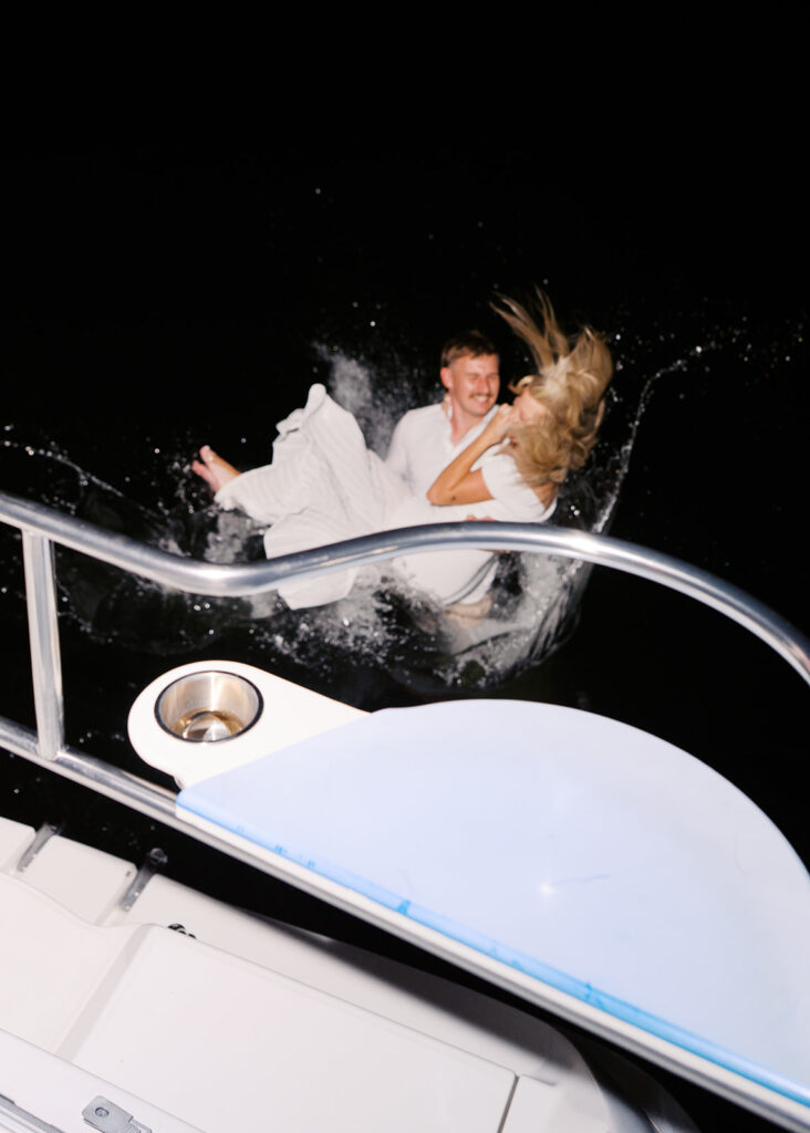 Playful Lake Travis sailboat engagement photos as the couple jumps off the boat for a spontaneous swim.
