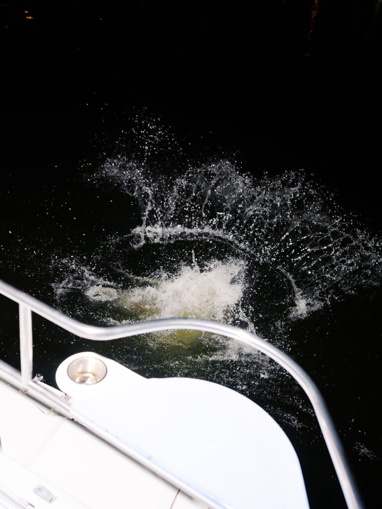 Playful Lake Travis sailboat engagement photos as the couple jumps off the boat for a spontaneous swim.