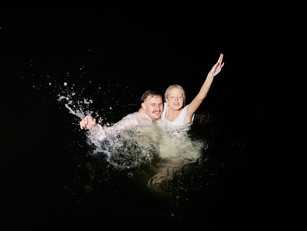 Playful Lake Travis sailboat engagement photos as the couple jumps off the boat for a spontaneous swim.