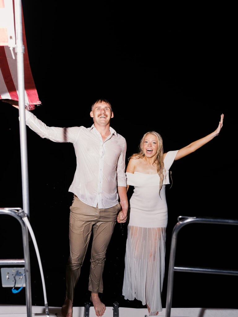 Playful Lake Travis sailboat engagement photos as the couple jumps off the boat for a spontaneous swim.