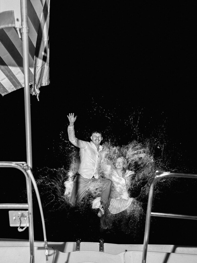 Playful Lake Travis sailboat engagement photos as the couple jumps off the boat for a spontaneous swim.