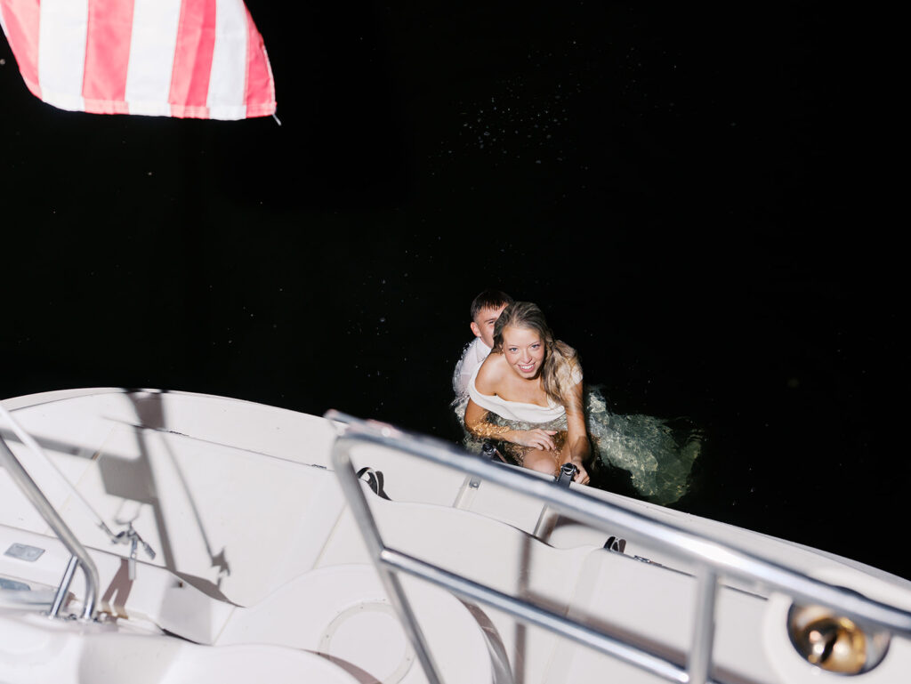 Playful Lake Travis sailboat engagement photos as the couple jumps off the boat for a spontaneous swim.
