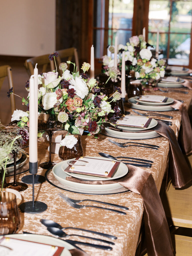 Romantic southern wedding tablescape at The Adelphia with lush florals, soft candlelight, and elegant rentals styled by Simply Bliss Events
