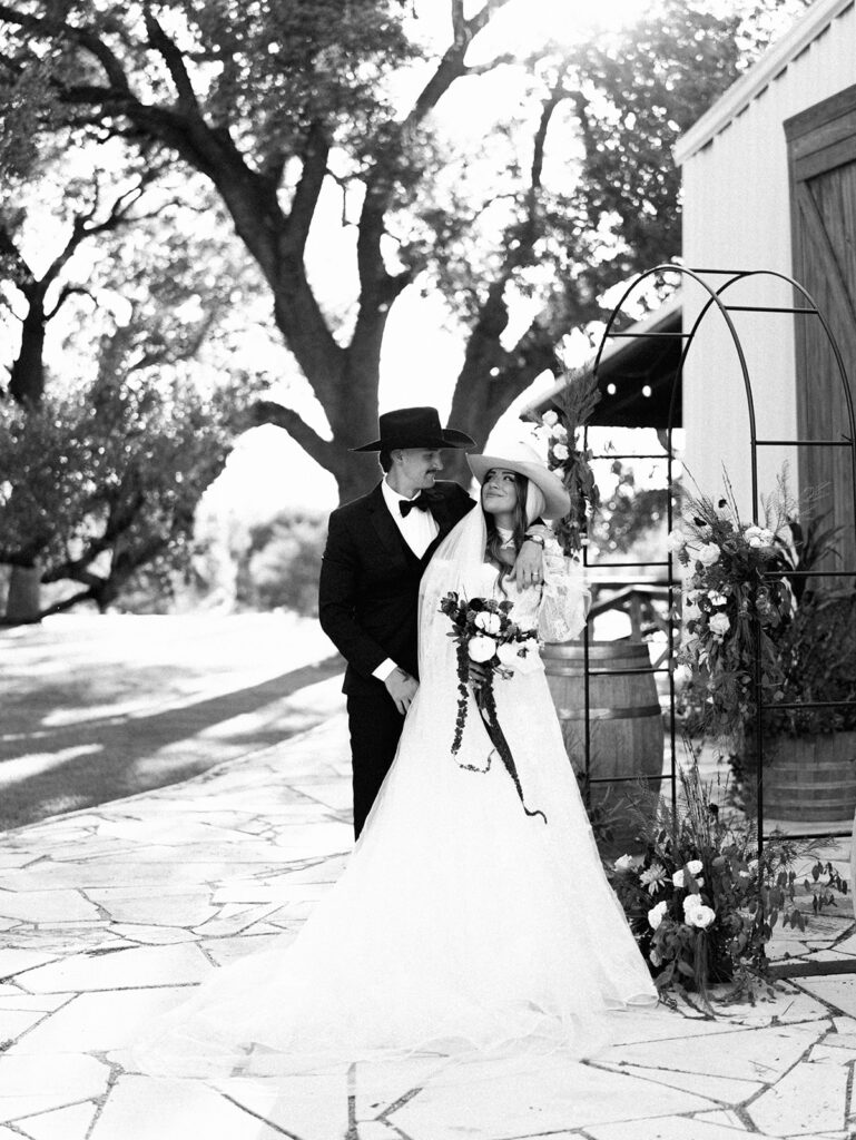 Bride and groom embracing at The Adelphia during a romantic southern wedding editorial, surrounded by lush florals and timeless charm
