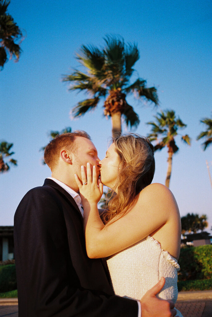 Candid laughter by the ocean at golden hour during Emma and Luke’s film engagement session at the Grand Galvez.