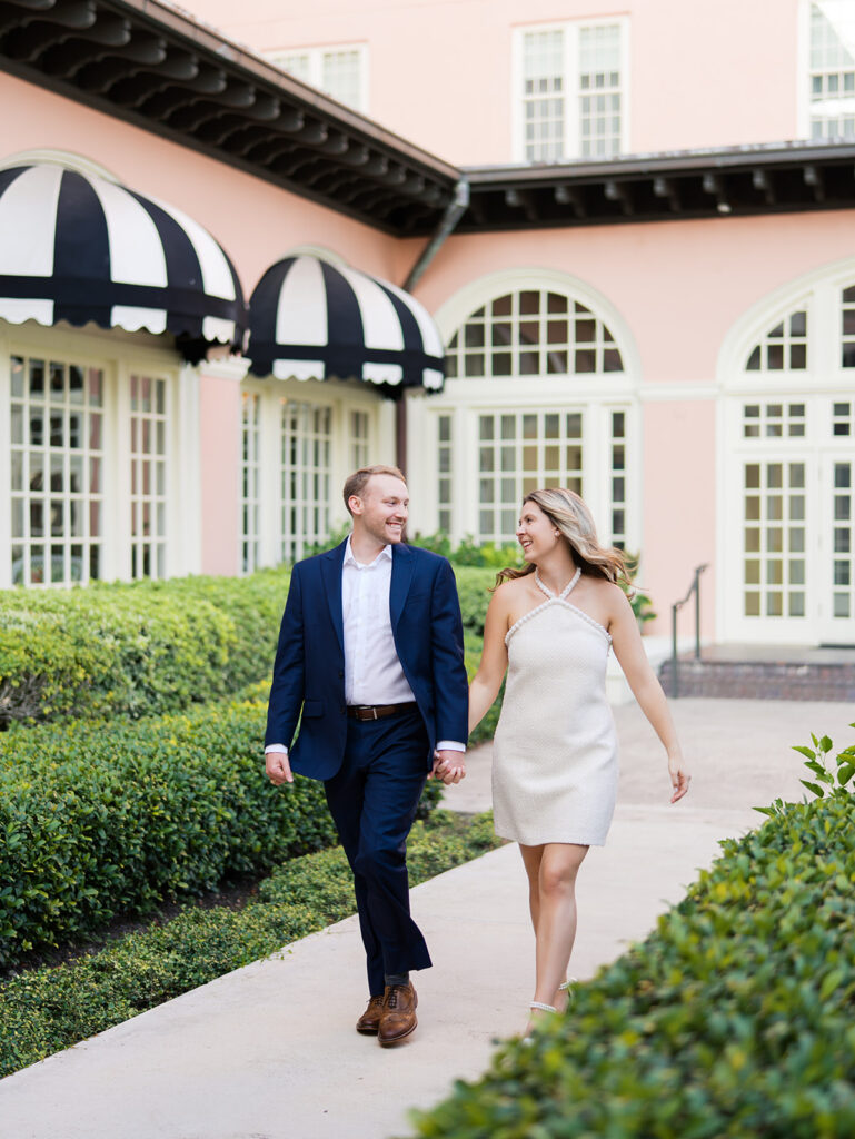 Emma and Luke smiling together in the Grand Galvez garden under tall palm trees captured on film with soft, natural light and timeless color.