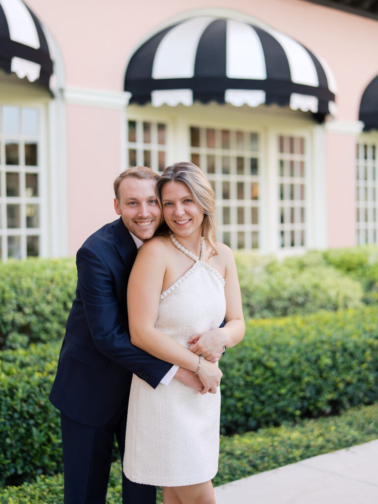Emma and Luke smiling together in the Grand Galvez garden under tall palm trees captured on film with soft, natural light and timeless color.