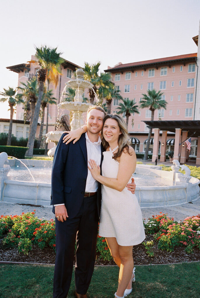 Candid laughter by the ocean at golden hour during Emma and Luke’s film engagement session at the Grand Galvez.