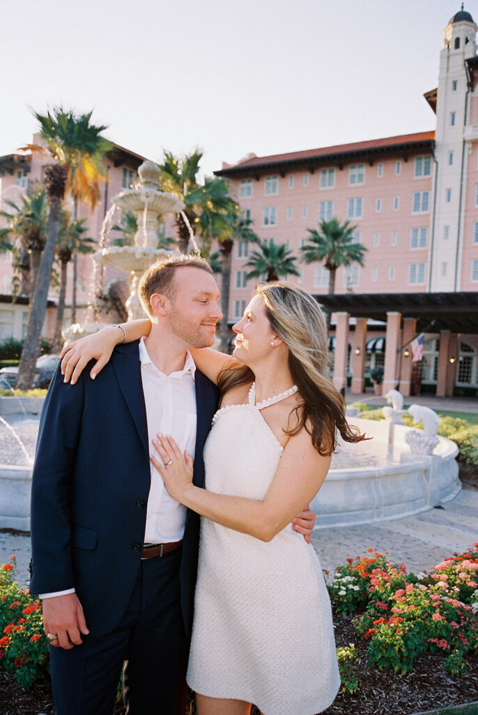 Candid laughter by the ocean at golden hour during Emma and Luke’s film engagement session at the Grand Galvez.