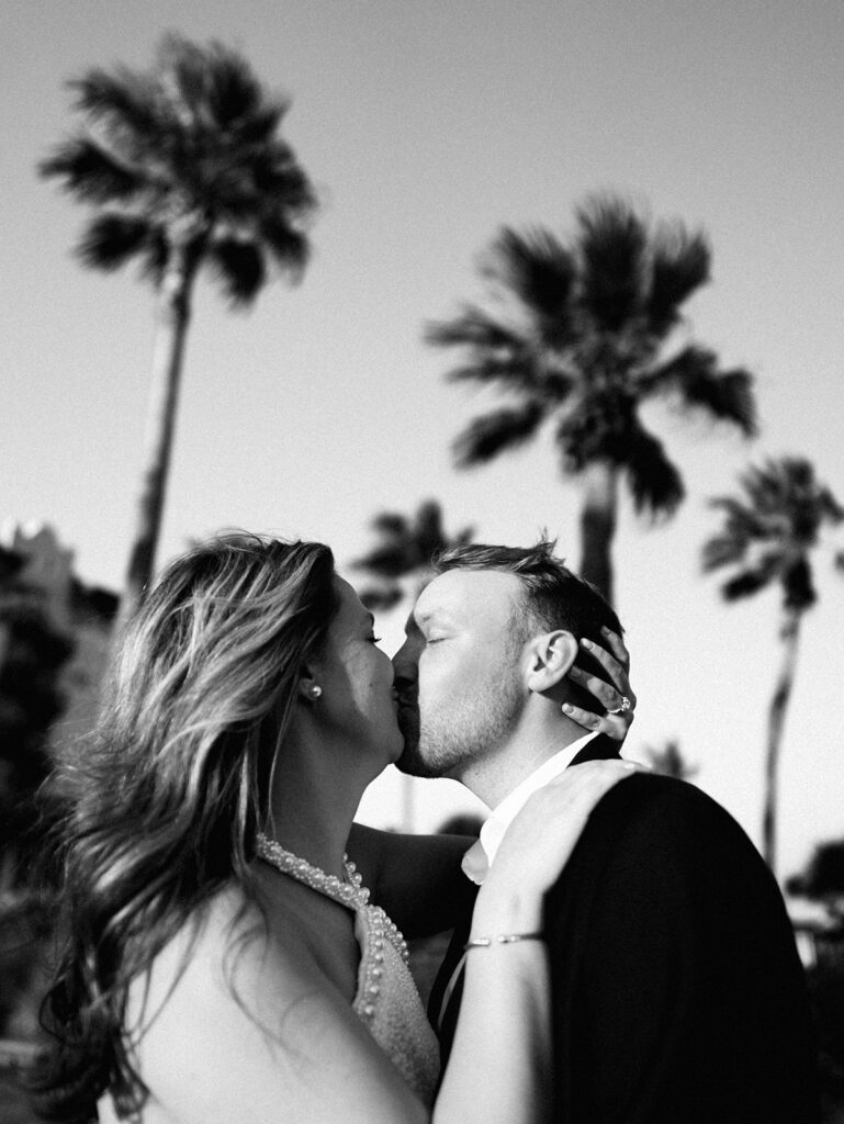 Candid laughter by the ocean at golden hour during Emma and Luke’s film engagement session at the Grand Galvez.