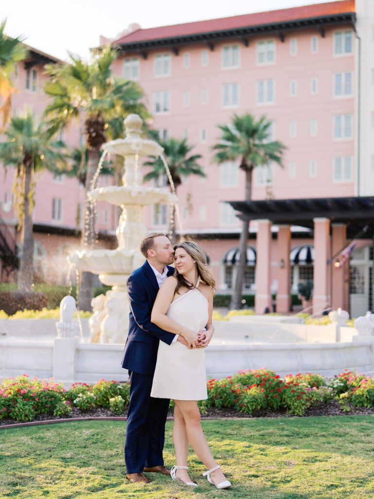 Candid laughter by the ocean at golden hour during Emma and Luke’s film engagement session at the Grand Galvez.