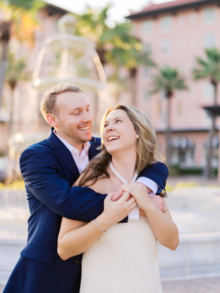 Candid laughter by the ocean at golden hour during Emma and Luke’s film engagement session at the Grand Galvez.