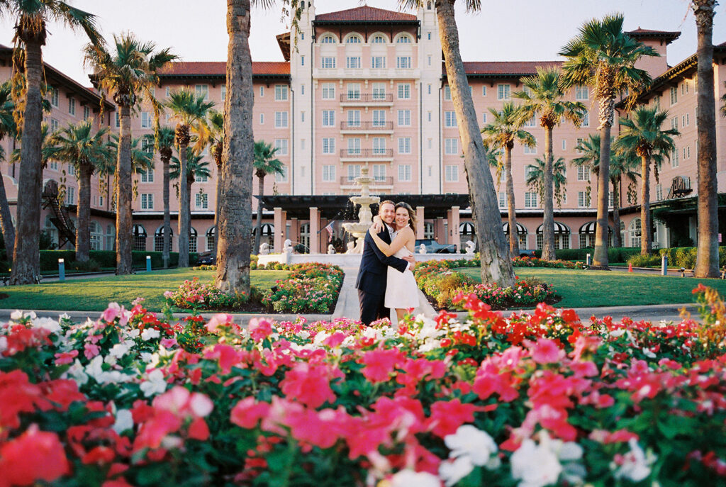 Emma twirling under palm trees while Luke smiles with vibrant timeless color captured on film