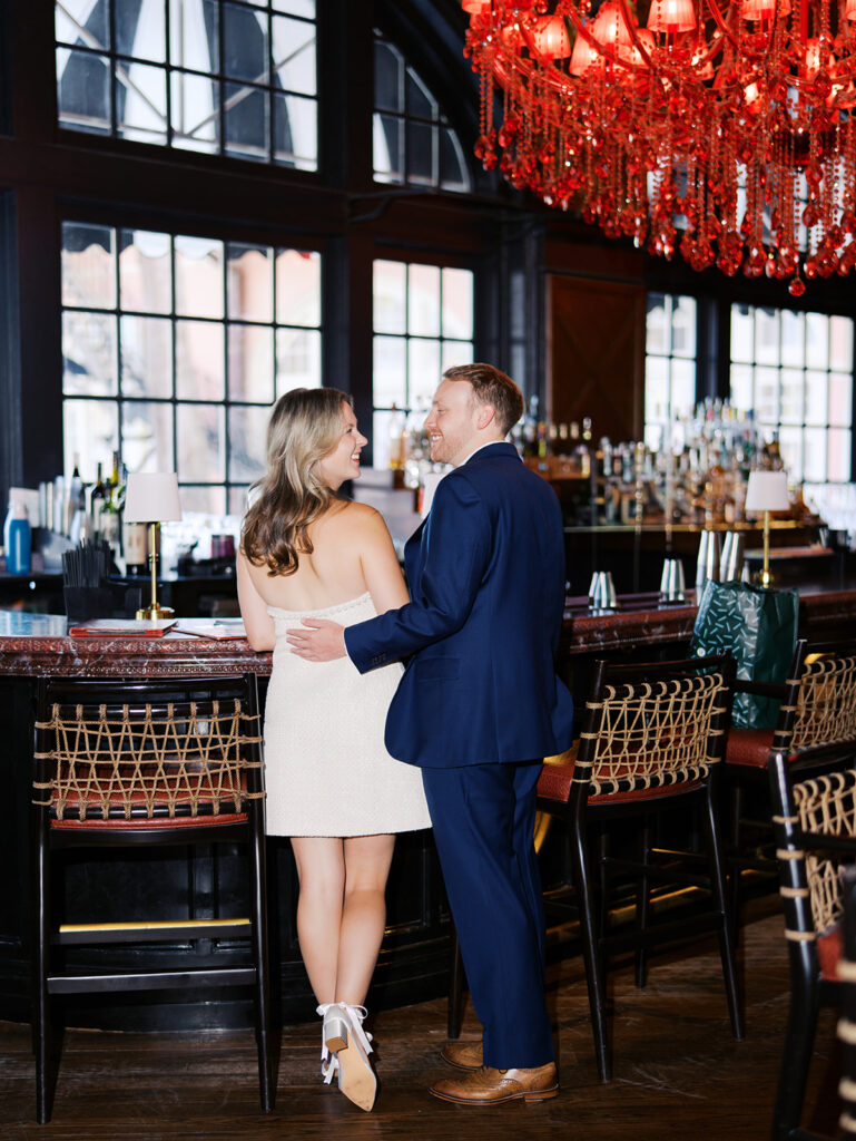 Emma and Luke cheersing and enjoying cocktails at the Grand Galvez bar photographed on film with a relaxed, romantic vibe