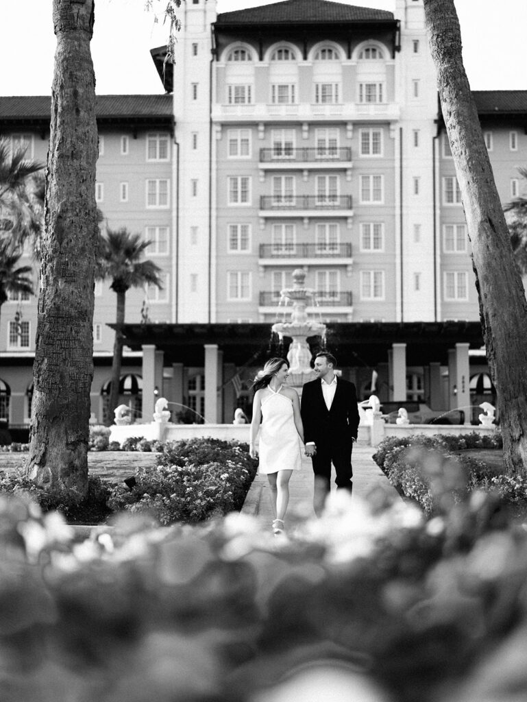 Emma twirling under palm trees while Luke smiles with vibrant timeless color captured on film