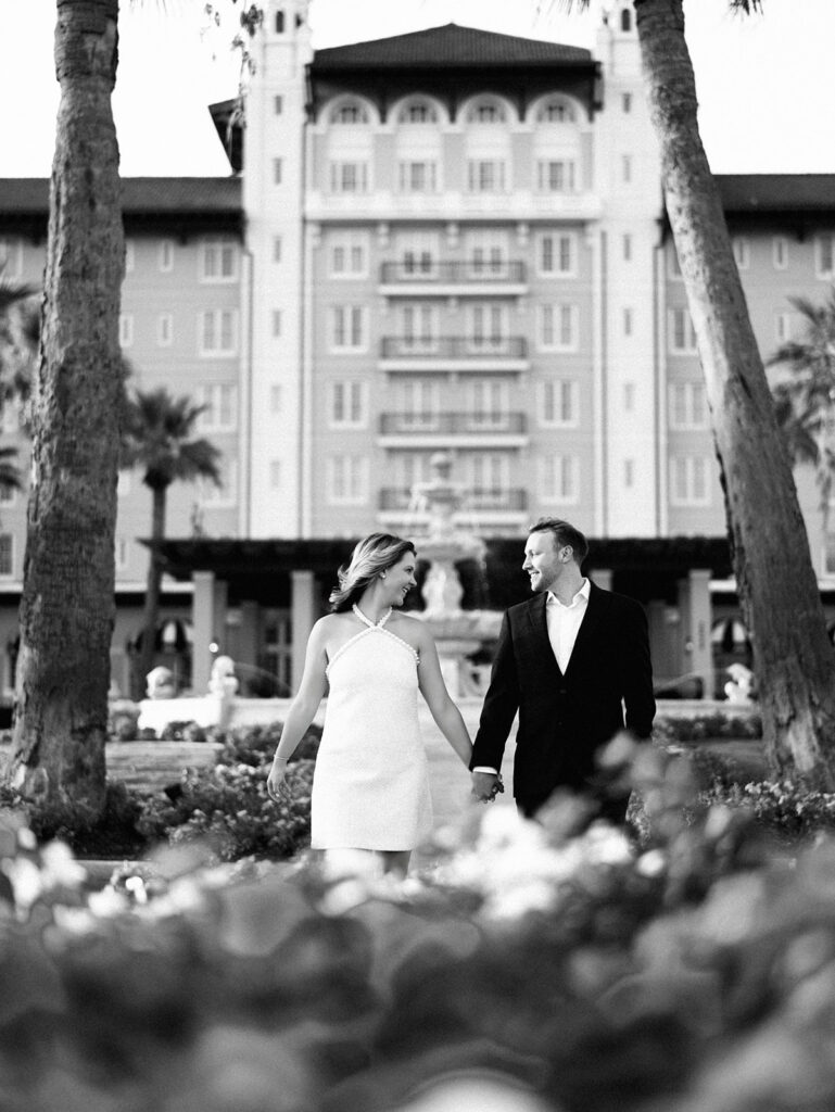 Emma twirling under palm trees while Luke smiles with vibrant timeless color captured on film