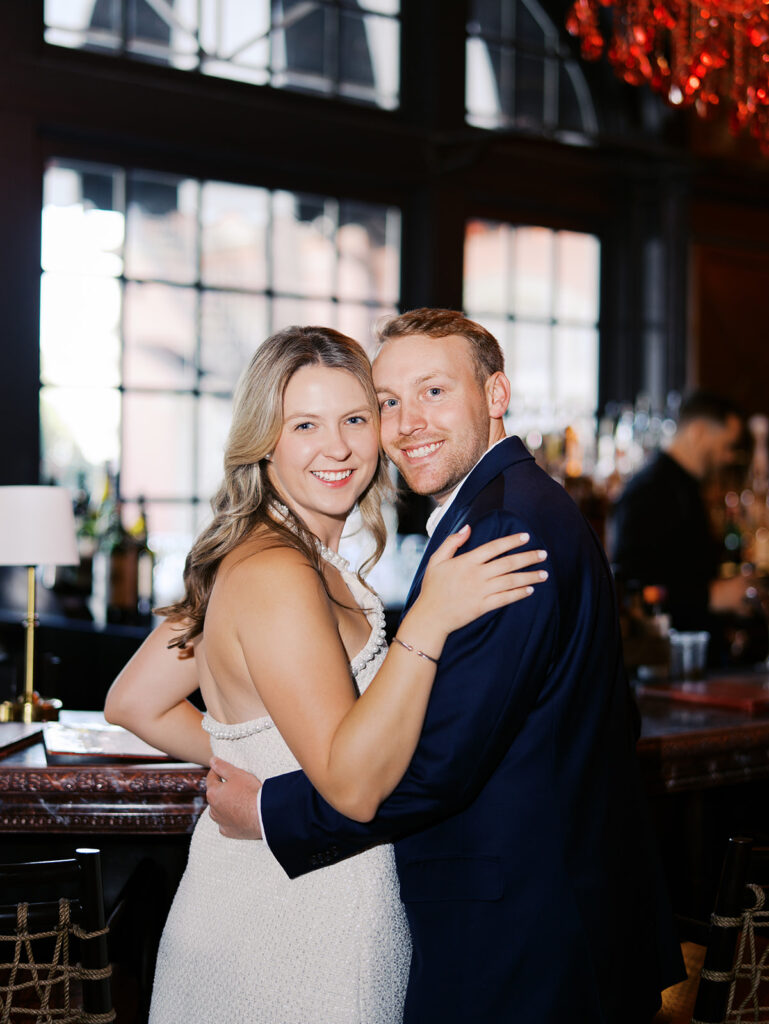 Emma and Luke cheersing and enjoying cocktails at the Grand Galvez bar photographed on film with a relaxed, romantic vibe