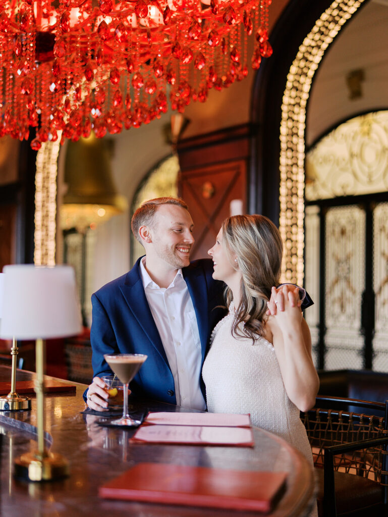 Emma and Luke cheersing and enjoying cocktails at the Grand Galvez bar photographed on film with a relaxed, romantic vibe