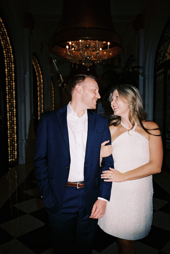 Emma and Luke cheersing and enjoying cocktails at the Grand Galvez bar photographed on film with a relaxed, romantic vibe