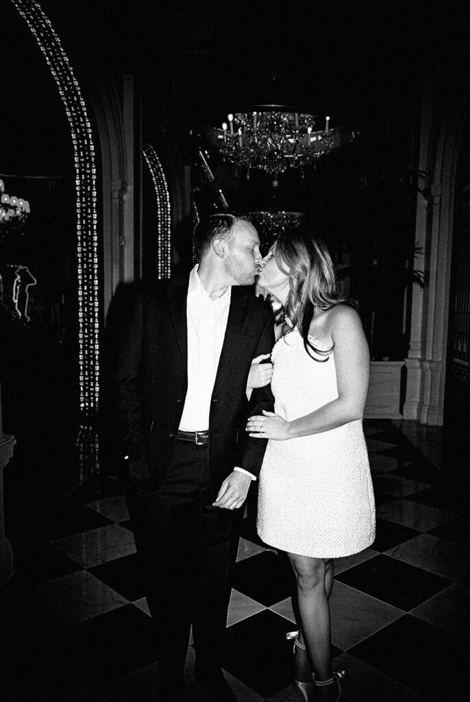Emma and Luke cheersing and enjoying cocktails at the Grand Galvez bar photographed on film with a relaxed, romantic vibe