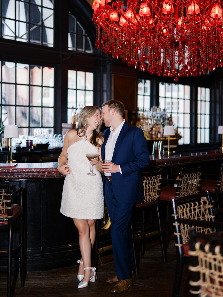 Emma and Luke cheersing and enjoying cocktails at the Grand Galvez bar photographed on film with a relaxed, romantic vibe