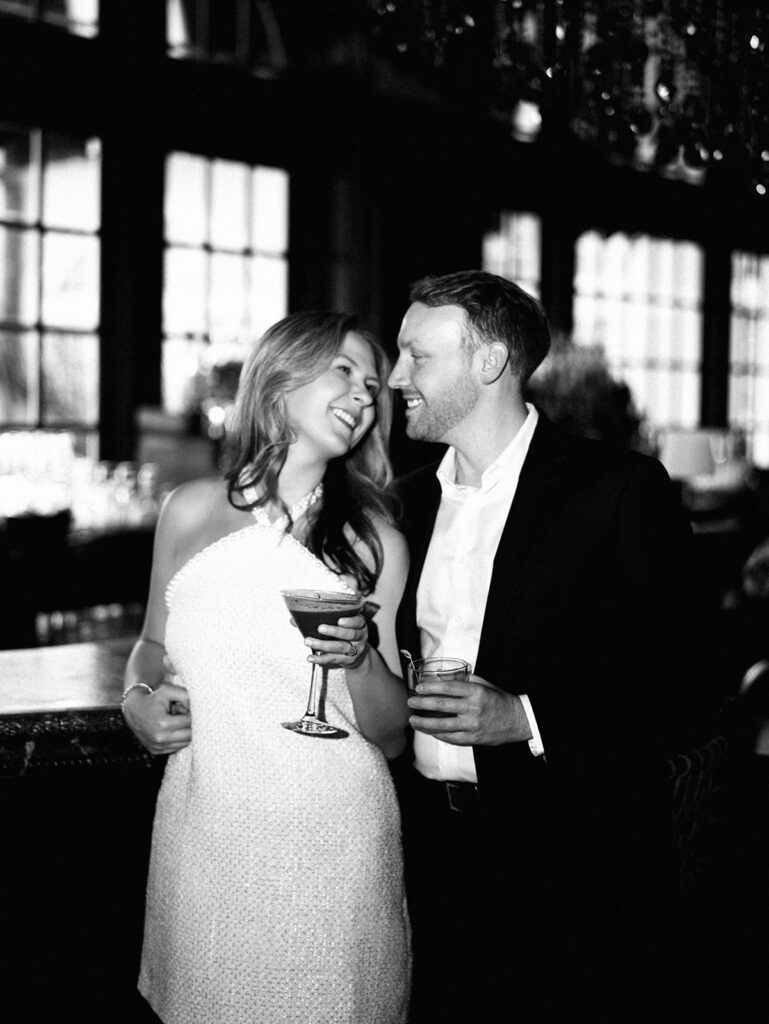 Emma and Luke cheersing and enjoying cocktails at the Grand Galvez bar photographed on film with a relaxed, romantic vibe