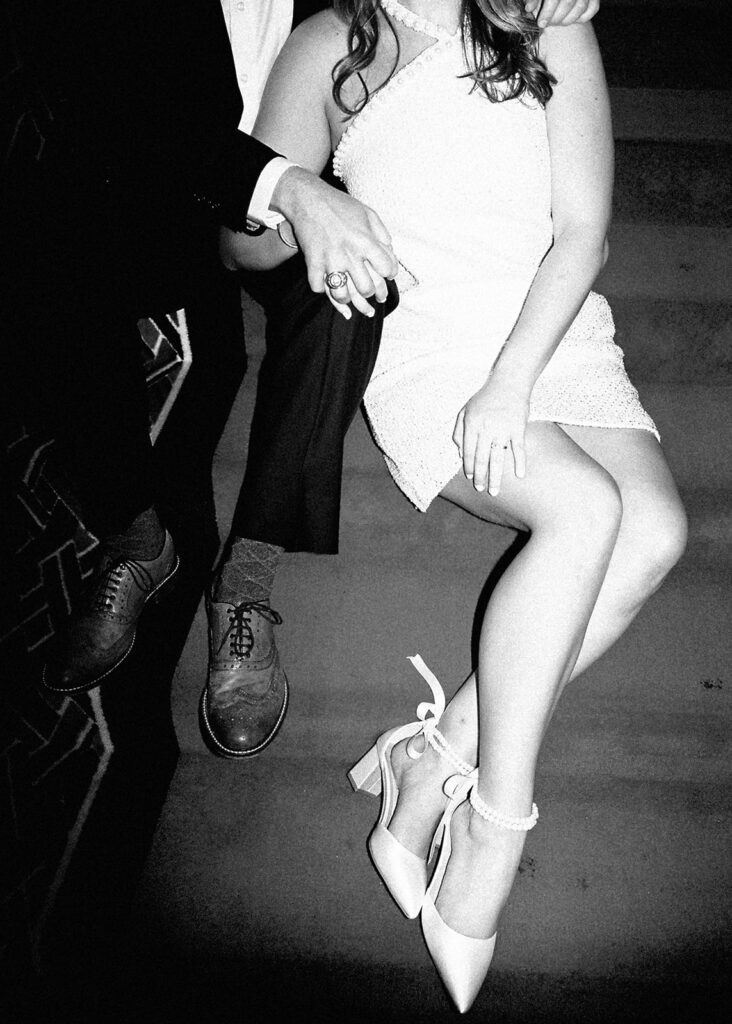 Emma and Luke cheersing and enjoying cocktails at the Grand Galvez bar photographed on film with a relaxed, romantic vibe