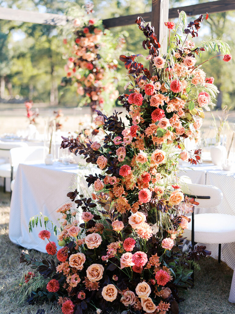 Floral installation by By Maggie Peterson with rich amber, rust, and blush tones