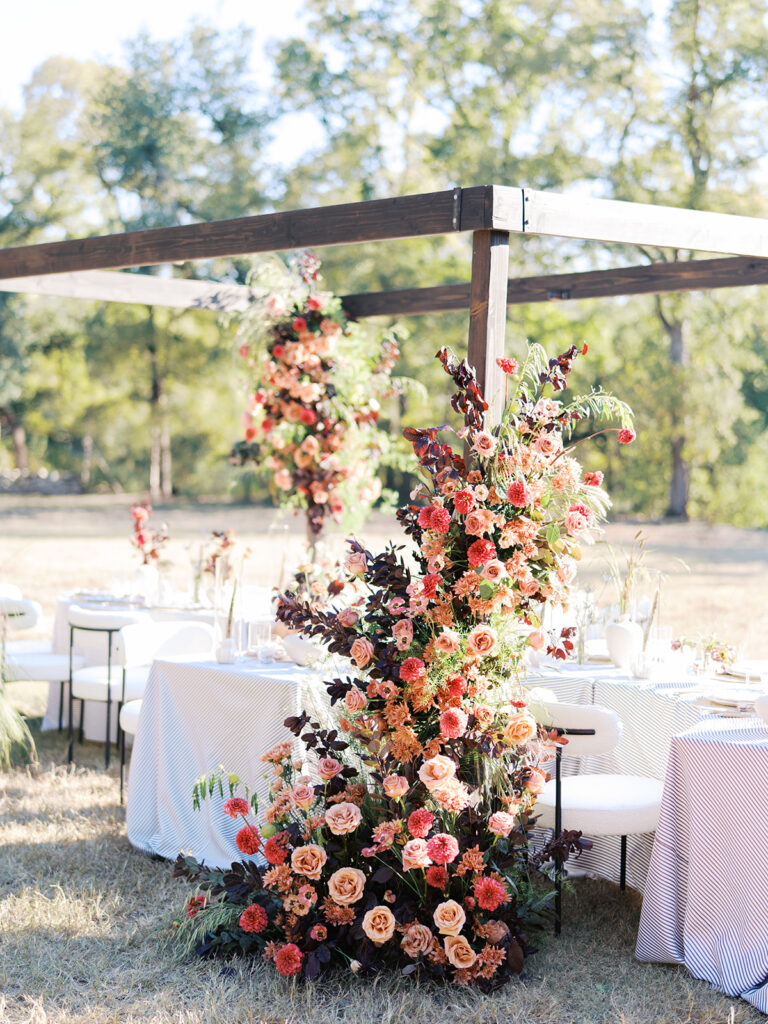 Floral installation by By Maggie Peterson with rich amber, rust, and blush tones