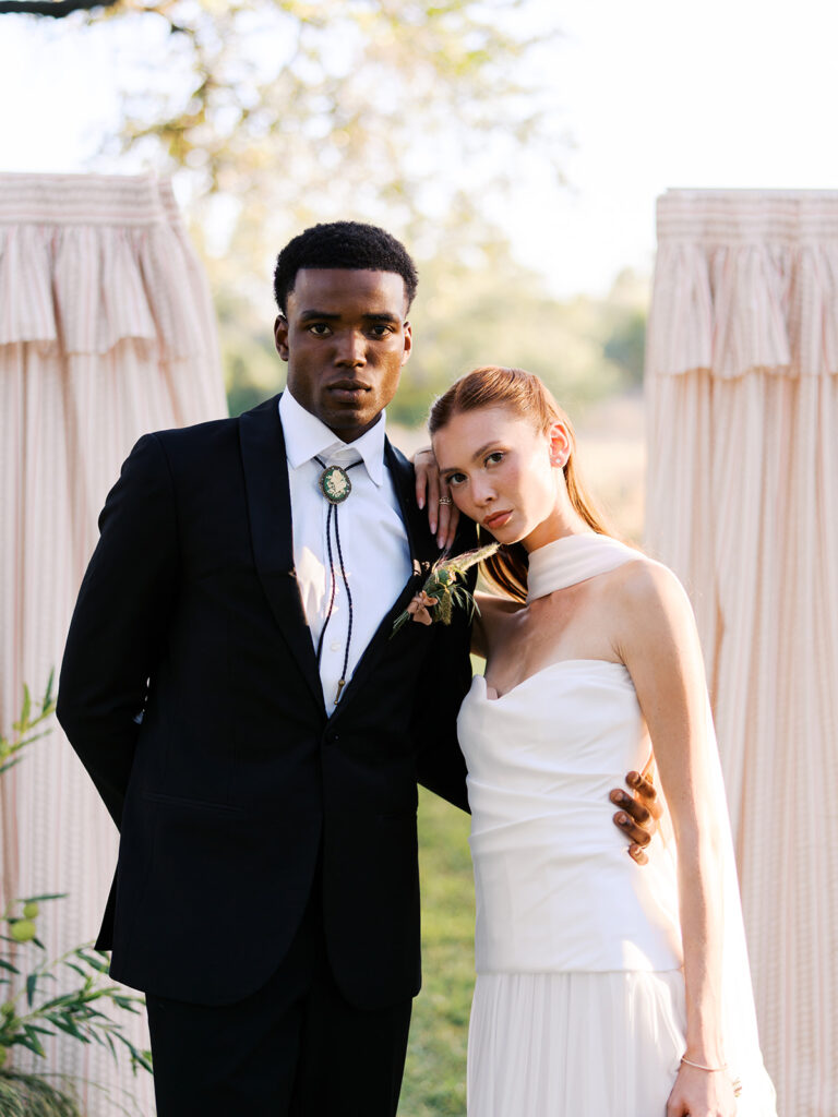 Bride and groom walking through The Addison Grove surrounded by golden fall foliage and lush florals