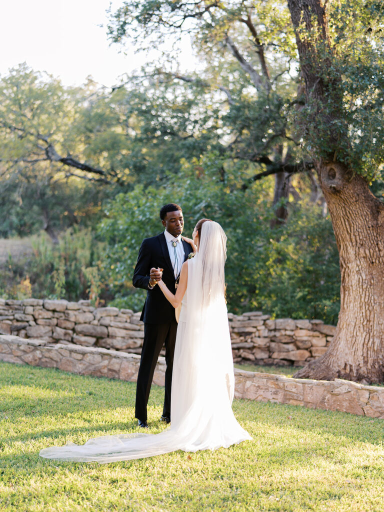 Bride and groom walking through The Addison Grove surrounded by golden fall foliage and lush florals