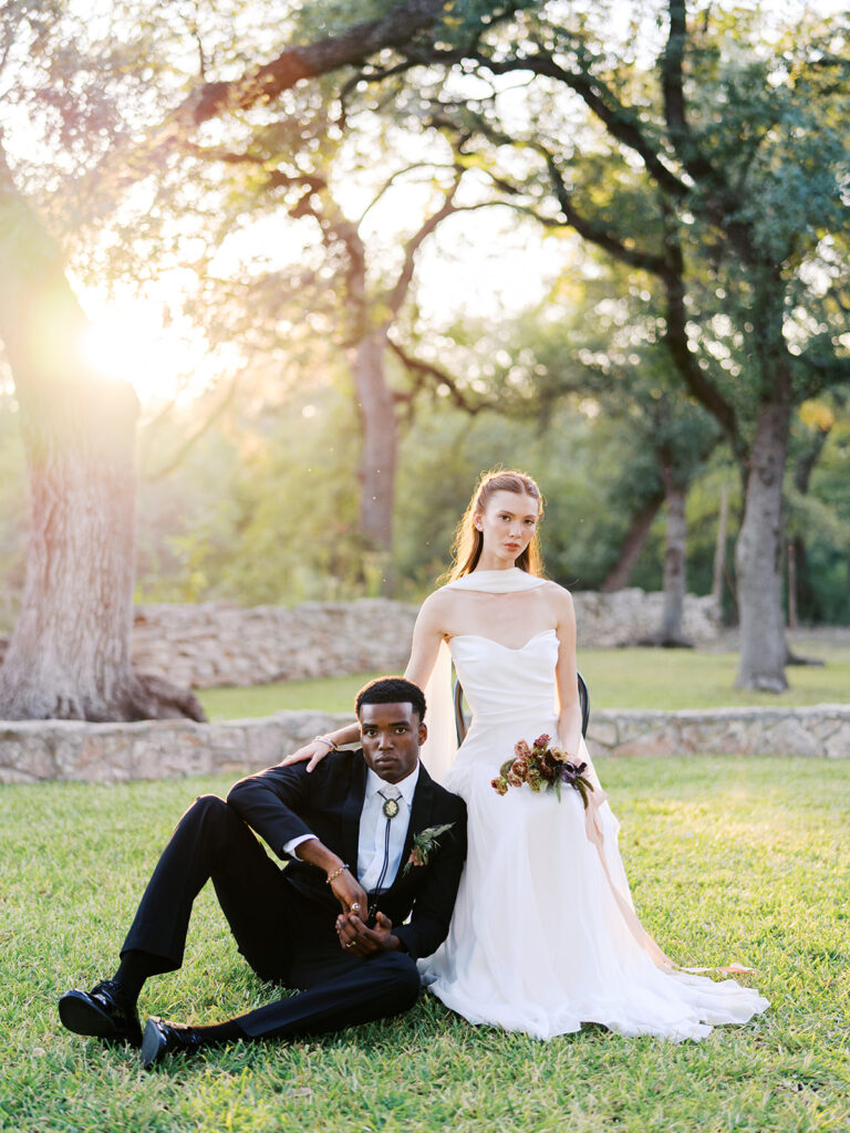 Bride and groom walking through The Addison Grove surrounded by golden fall foliage and lush florals