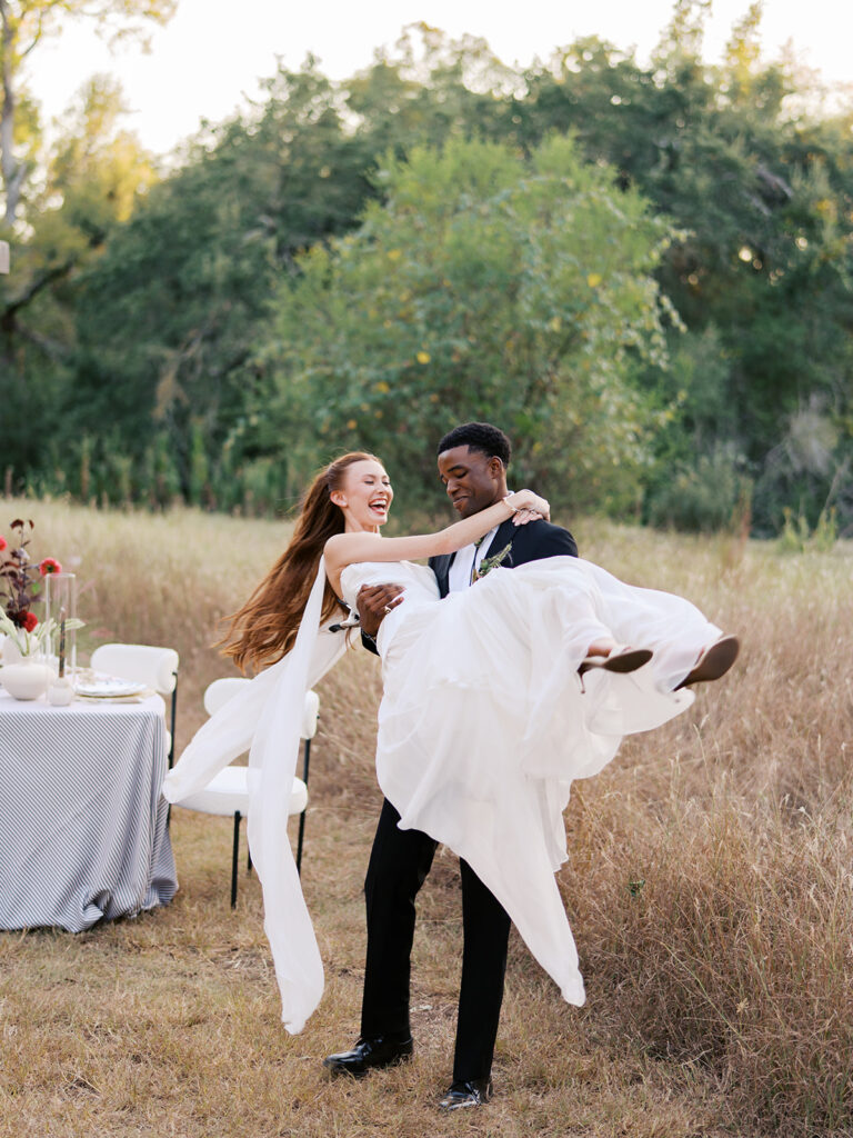 Bride and groom walking through The Addison Grove surrounded by golden fall foliage and lush florals