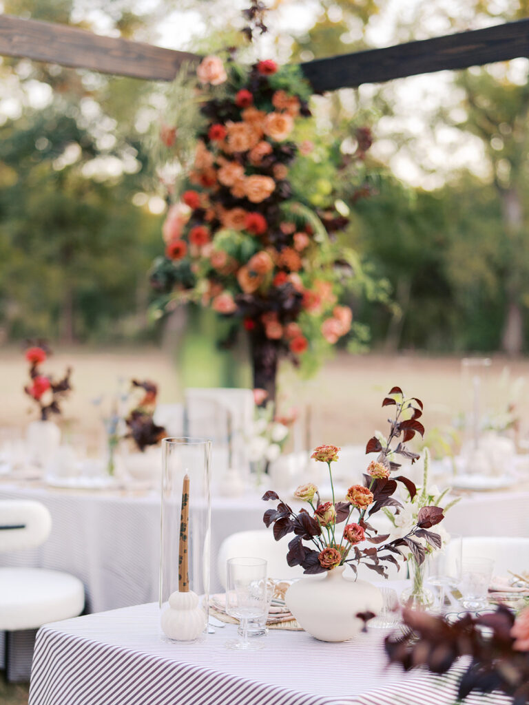 Floral installation by By Maggie Peterson with rich amber, rust, and blush tones