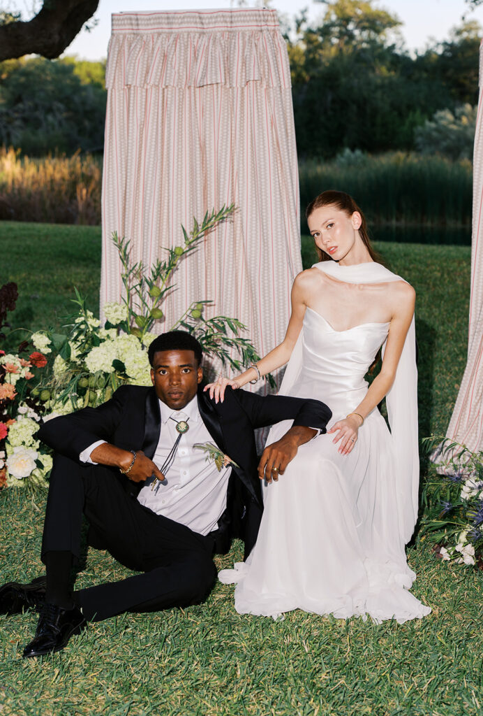 Bride and groom walking through The Addison Grove surrounded by golden fall foliage and lush florals