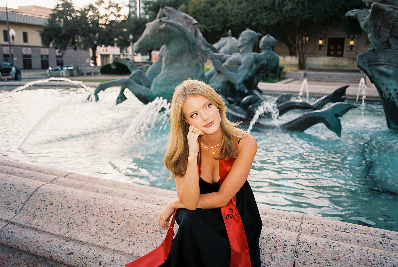 UT Austin grad photos at Littlefield Fountain during golden hour, capturing joyful senior portraits full of color and celebration.